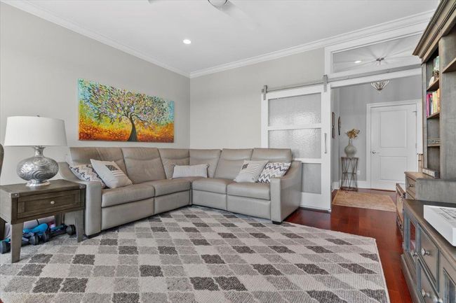 Living room with ceiling fan, visible vents, ornamental molding, and wood finished floors | Image 17