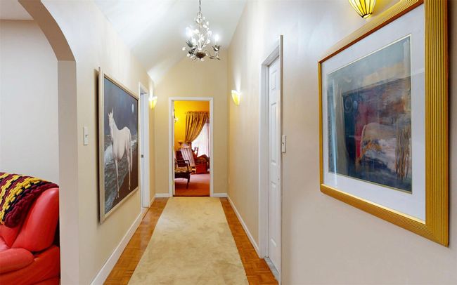Hallway with arched walkways, a chandelier, and baseboards | Image 33