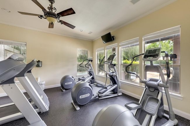 Gym with ceiling fan, ornamental molding, and healthy amount of natural light | Image 27