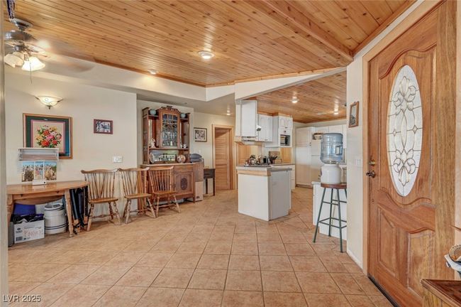 Entrance foyer with wood ceiling, light tile patterned floors, and ceiling fan | Image 27