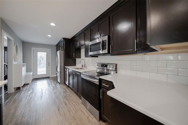 Kitchen with appliances with stainless steel finishes, light countertops, tasteful backsplash, recessed lighting, and light wood-style floors | Image 12