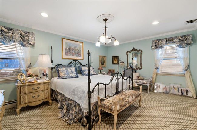 Carpeted bedroom featuring crown molding, baseboard heating, recessed lighting, and visible vents | Image 14
