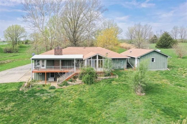 Back of property with a chimney, stairs, a lawn, a sunroom, and a deck | Image 6