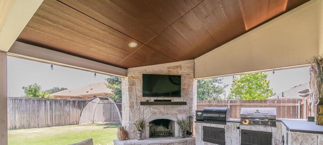 Fenced backyard with area for grilling and an outdoor stone fireplace | Image 15