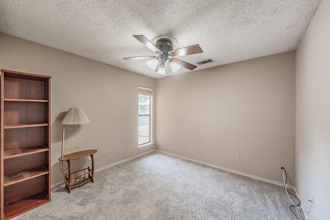 Carpeted empty room featuring a ceiling fan and a textured ceiling | Image 19