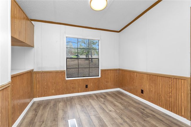 Spare room with wainscoting, hardwood / wood-style floors, wood walls, and ornamental molding | Image 10