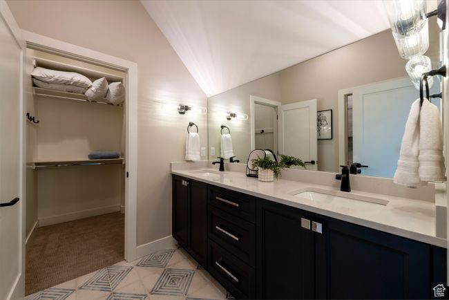 Bathroom featuring double vanity, lofted ceiling, and a spacious closet | Image 51
