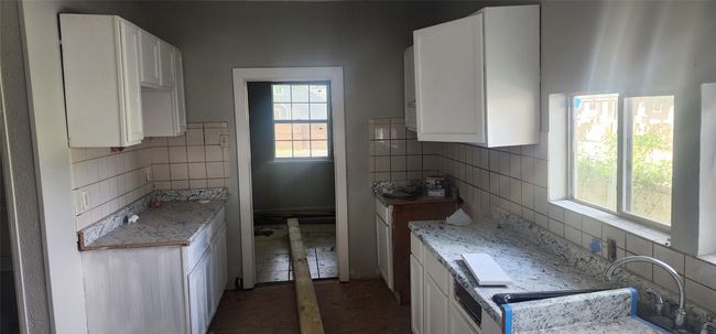 Kitchen with backsplash and white cabinets | Image 11