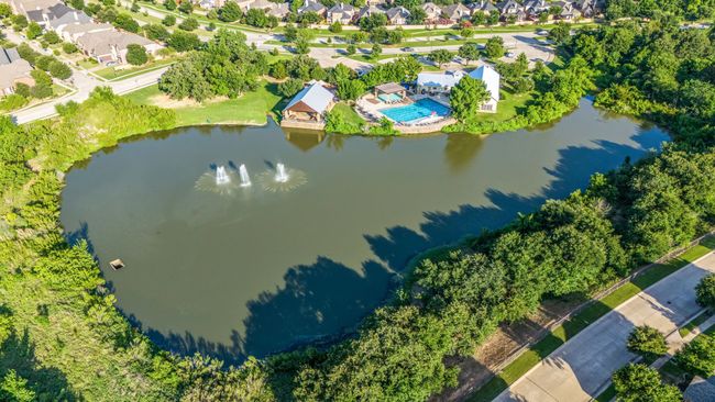 Aerial perspective of suburban area featuring a nearby body of water and a pool area | Image 19