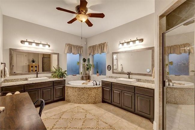 Primary suite features his and her vanity with a spacious soaking tub to enhance your relaxation experience. | Image 26