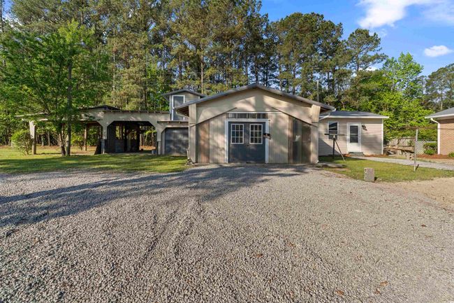 View of front of house with a front yard, gravel driveway, an outdoor structure, and french doors | Image 5