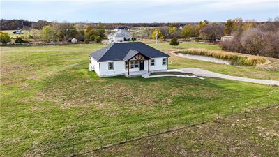 View of front of property featuring a porch, a water view, and a front yard | Image 1