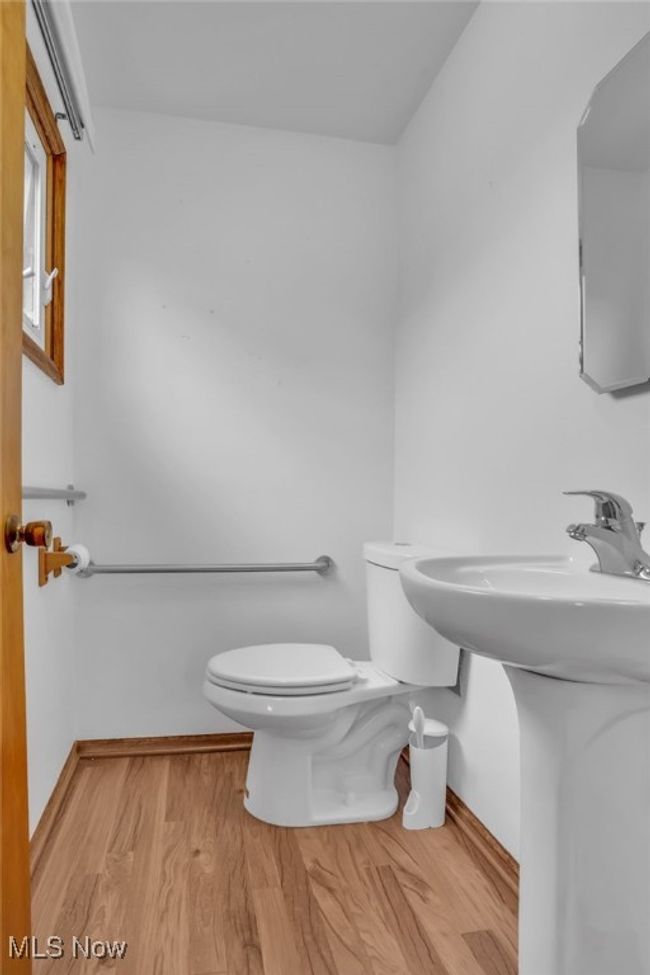 Half bath featuring toilet, wood finished floors, and baseboards | Image 17