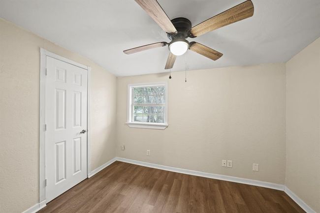 Wonderfully appointed secondary bedroom, featuring neutral paint, vinyl plank floors, and a ceiling fan. | Image 15