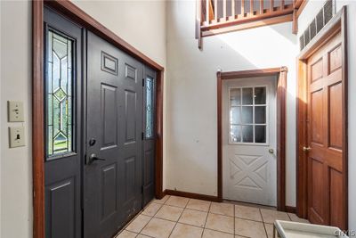 The large foyer features a 2-story vaulted ceiling. Ahead is the door into the 1-car garage, as well as the door into the laundry & mechanical room for this side. | Image 3