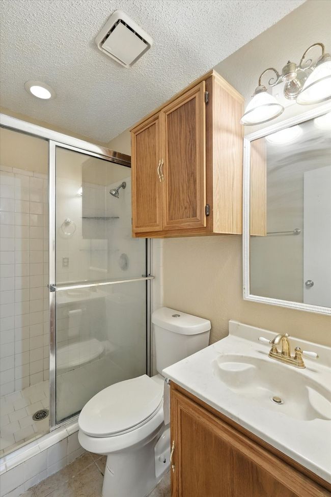 Bathroom featuring a shower stall, vanity, and a textured ceiling | Image 11