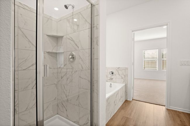 Bathroom with a garden tub, wood finished floors, and a marble finish shower | Image 17