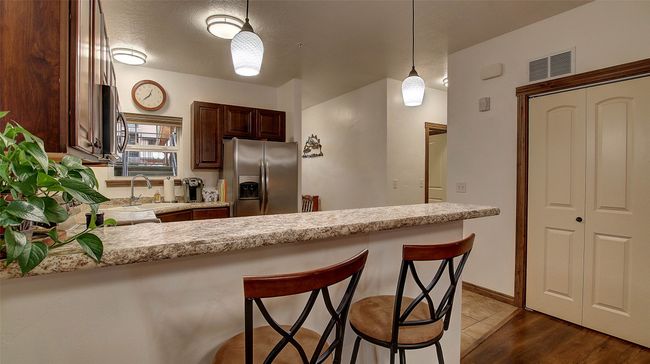 Kitchen with breakfast bar, range, refrigerator, dishwasher, microwave and plenty of storage | Image 17