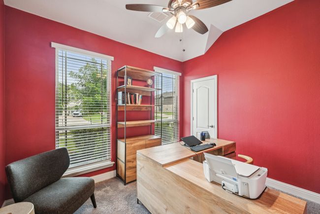This room is 4th bedroom with big walk-in closet. Current use is an office. Carpeted home office with ceiling fan, lofted ceiling, and 2 big windows for added lights | Image 8