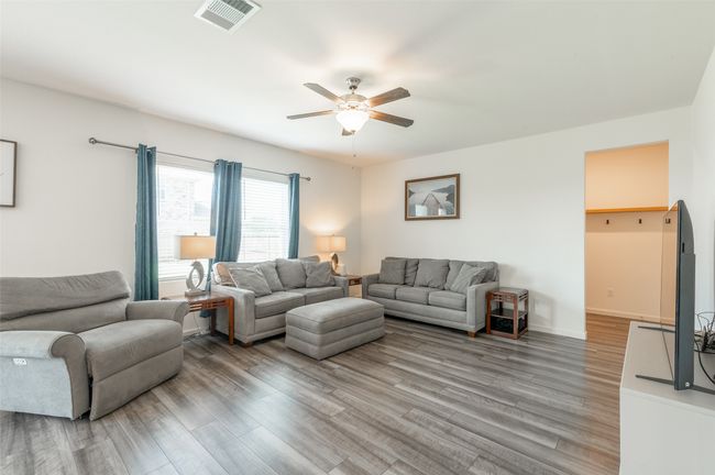 Living room with ceiling fan, light wood-style floors, and baseboards | Image 14