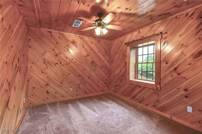 Lower level bedroom, wood walls, ceiling fan and window | Image 35