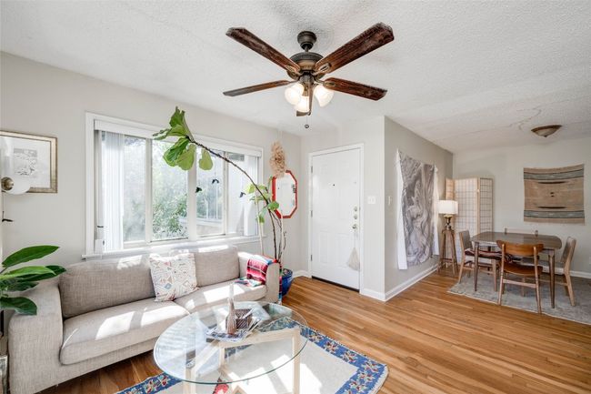 Living area with ceiling fan, wood finished floors, a textured ceiling, and baseboards | Image 34