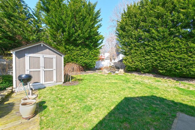 View of yard featuring an outdoor structure, a shed, and fence | Image 15