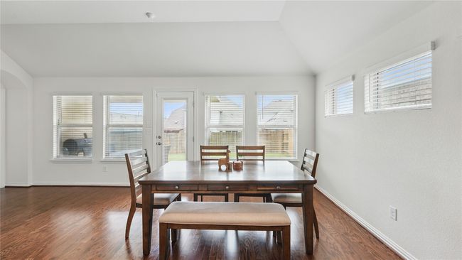 Dining space with lofted ceiling and dark wood finished floors | Image 9