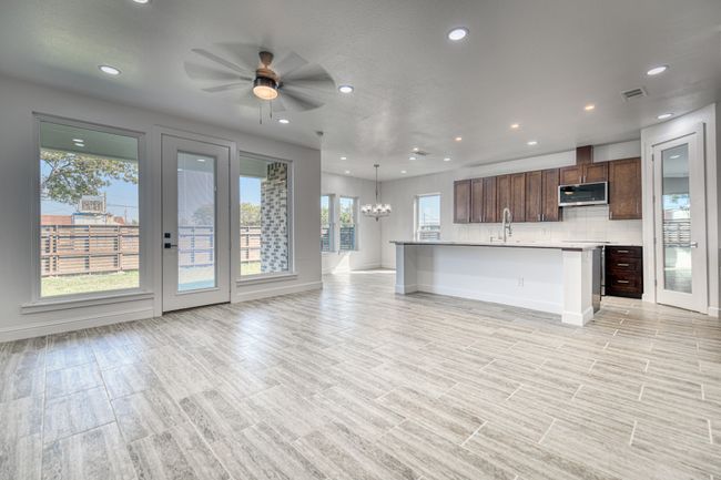 Unfurnished living room featuring sink and ceiling fan with notable chandelier | Image 15