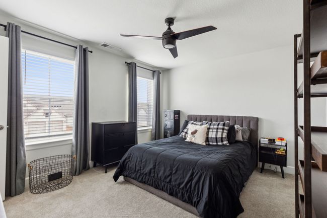 Bedroom featuring a ceiling fan, visible vents, and light carpet | Image 23