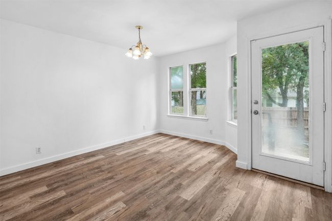 Unfurnished dining area with an inviting chandelier, baseboards, and wood finished floors | Image 10