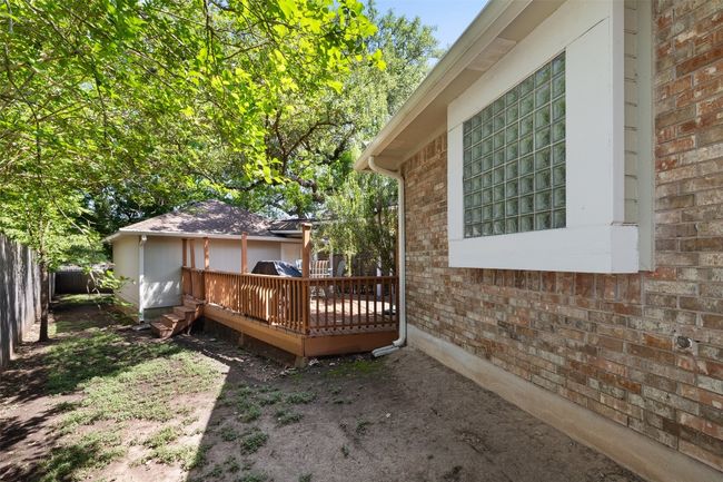 View of side of home featuring brick siding, a wooden deck, and fence | Image 38