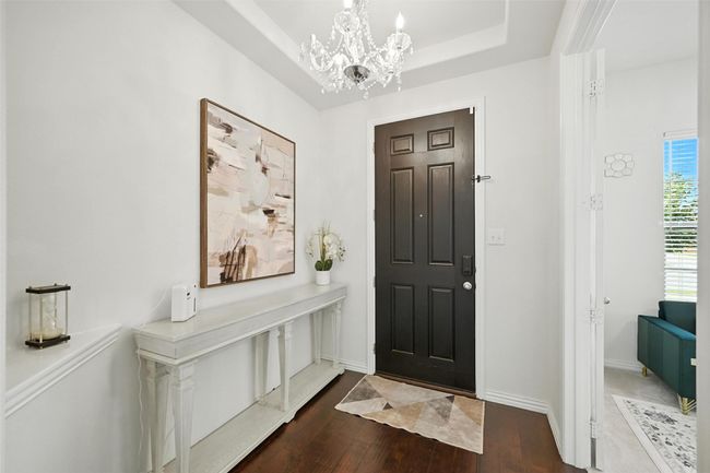 Foyer with wood finished floors, a chandelier, and a tray ceiling | Image 5