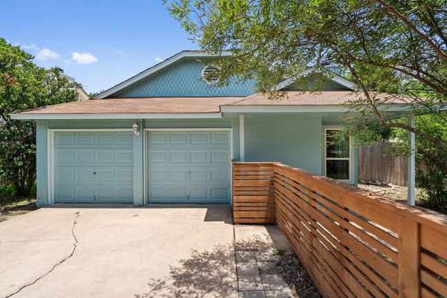View of front of home featuring driveway, an attached garage, roof with shingles, and a porch | Image 23