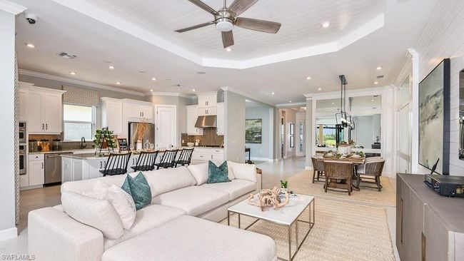 Living room with visible vents, recessed lighting, crown molding, a ceiling fan, and a tray ceiling | Image 8