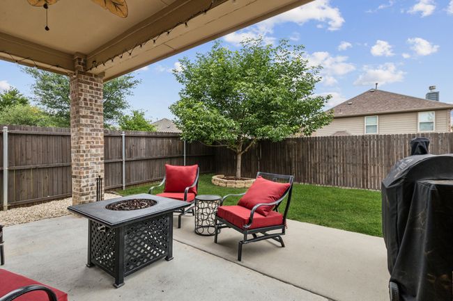 View of patio / terrace featuring a fire pit, grilling area, a fenced backyard, and a ceiling fan | Image 25