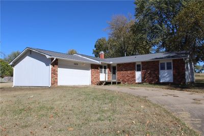 Ranch-style house with a garage and a front lawn | Image 1