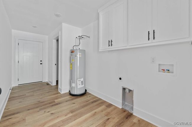 Laundry room with baseboards, washer hookup, electric water heater, hookup for an electric dryer, and cabinet space | Image 27