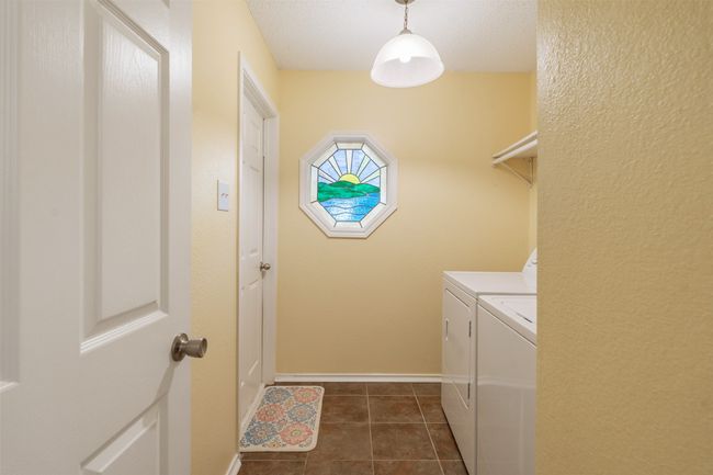 Laundry Room features space for a full sized washer and clothes dryer and dark tile patterned floors; quick entry from the garage. | Image 22