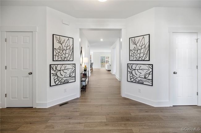 Bright hallway accented with modern artwork, leading to additional living spaces and private retreats. | Image 10
