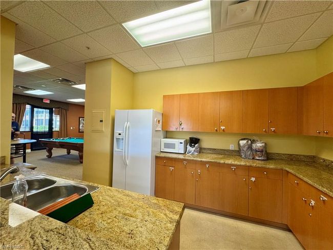 Kitchen with pool table, white appliances, brown cabinets, and a sink | Image 33