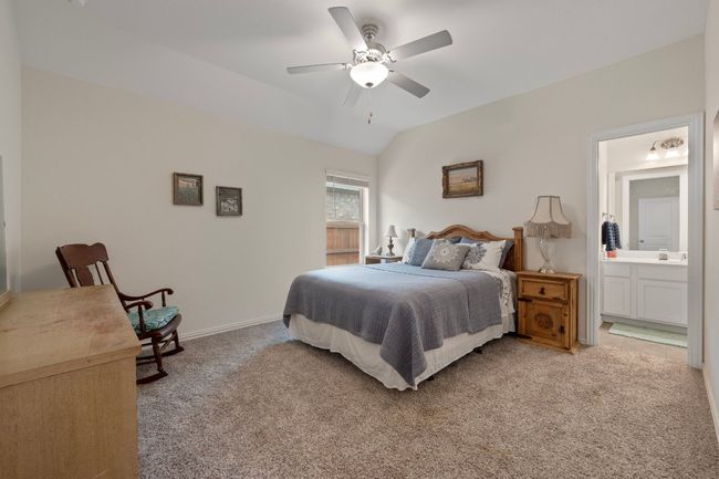 Bedroom featuring light carpet, vaulted ceiling, connected bathroom, a ceiling fan, and baseboards | Image 15