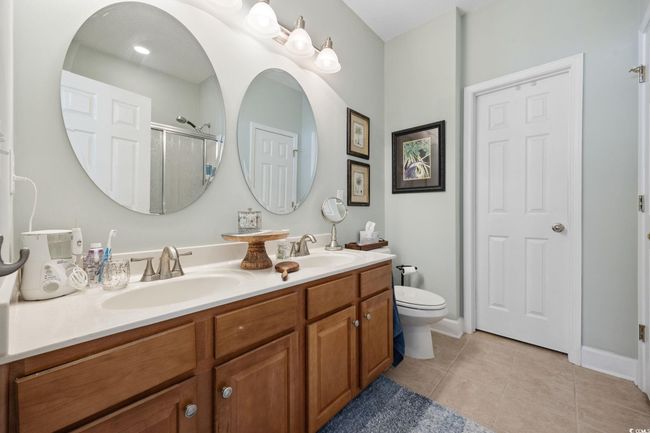 Full bathroom with tile patterned floors, double vanity, and a shower with door | Image 18