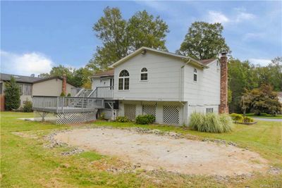 Rear view of house with a yard and a wooden deck | Image 3