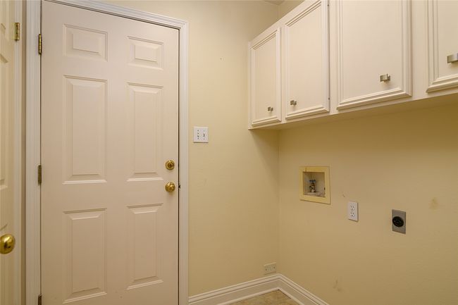 Laundry room featuring hookup for an electric dryer, cabinet space, washer hookup, and baseboards | Image 18