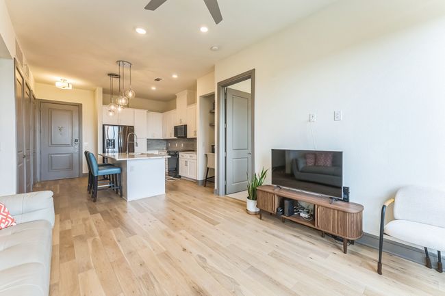 Living room with light wood-style flooring, ceiling fan, and recessed lighting | Image 5