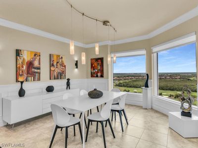 Dining room featuring light tile flooring, ornamental molding, plenty of natural light, and track lighting | Image 1