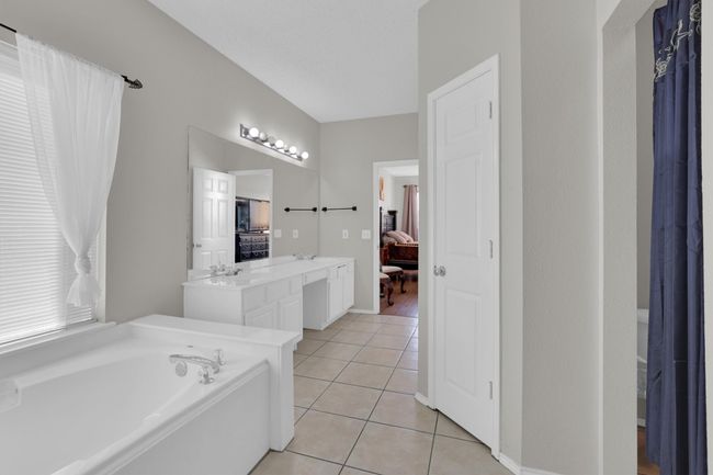 Full bath with ensuite bathroom, a sink, a bath, tile patterned floors, and double vanity | Image 19