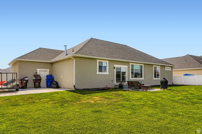 Back of house featuring a patio area, stucco siding, and roof with shingles | Image 24