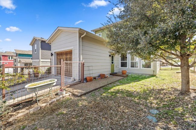 Back of house featuring an attached garage, a garden, and a yard | Image 26